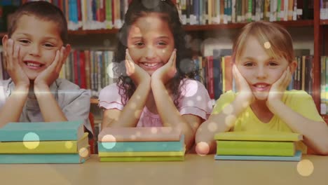 escolares apoyadas en una mesa y mirando a la cámara con libros delante de ellos en una biblioteca