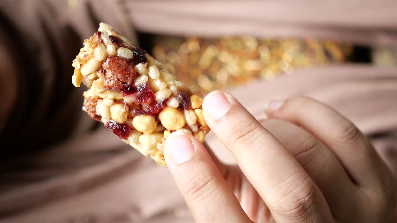 primer plano de una persona comiendo una deliciosa barra de granola
