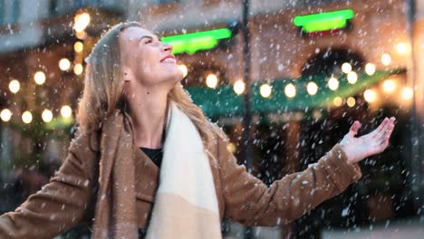 vista cercana de la mujer caucásica girando y sonriendo bajo la nieve en la calle en navidad