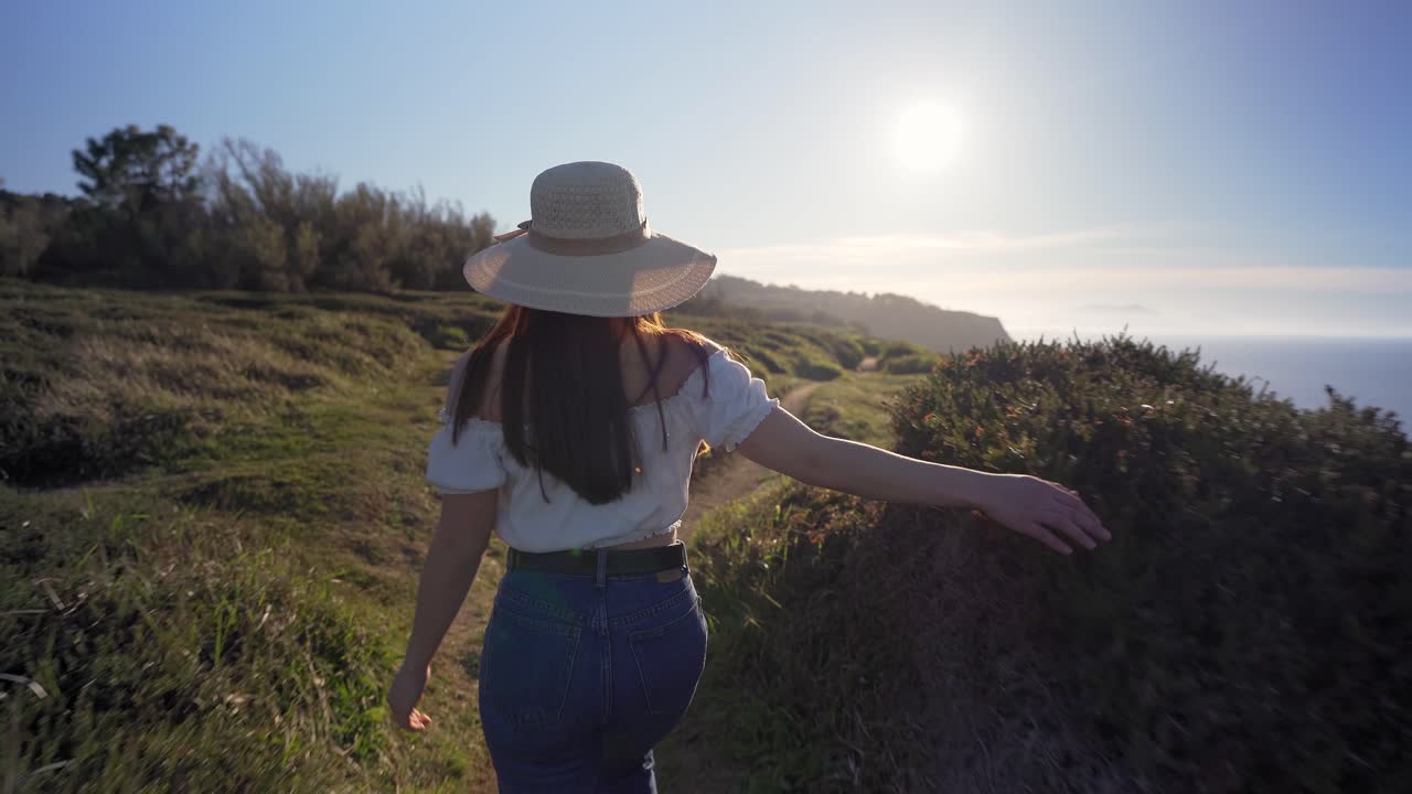 mujer caminando por el verde campo de hierba