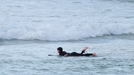 surfer paddling and catching waves in the ocean