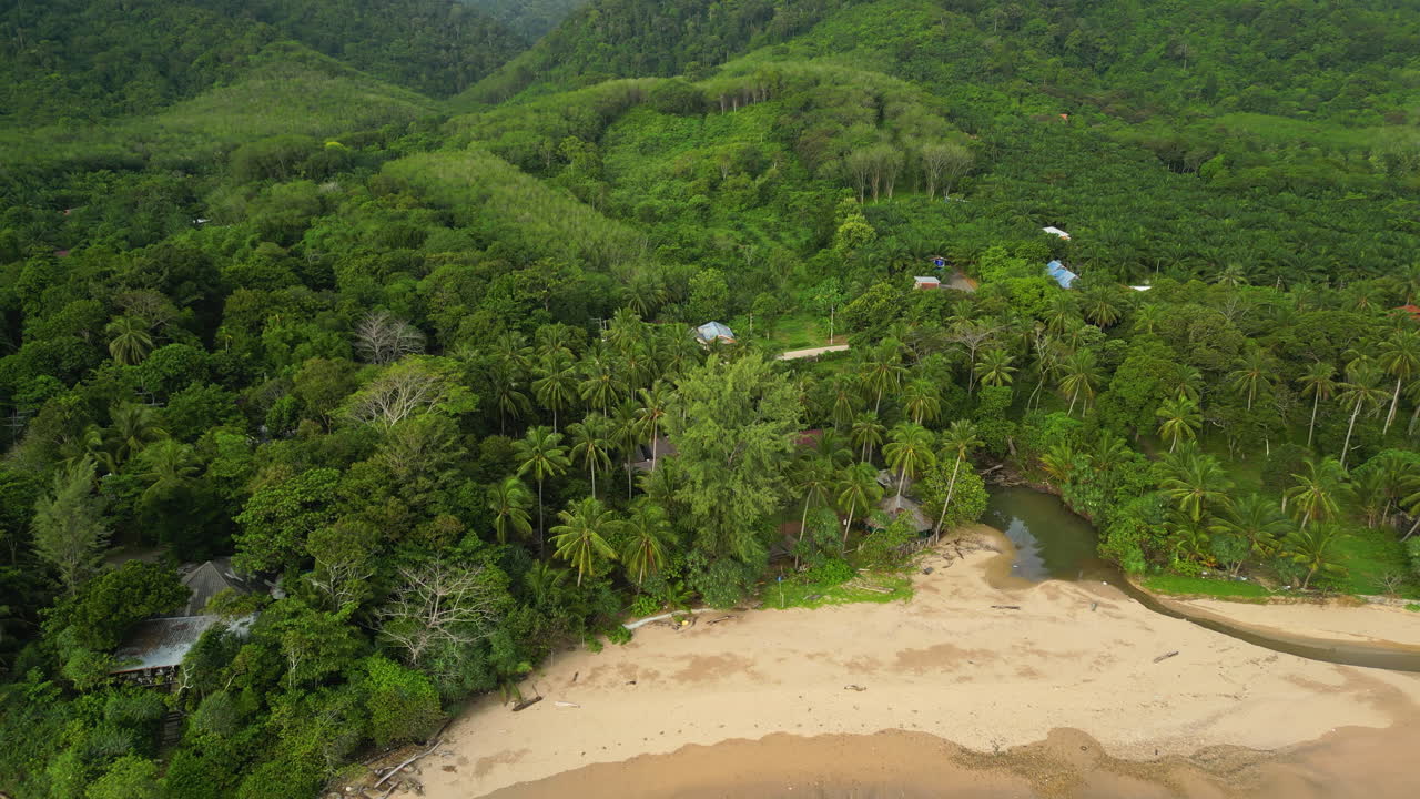 toma aérea de las colinas del bosque tropical con playa de arena y río en koh lanta en tailandia