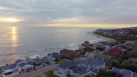 Sudáfrica-Dron-Aéreo-Jeffreys-Bay-Surf-Pueblo-Maravilloso-Temprano-En-La-Mañana-Amanecer-Sol-Dorado-En-El-Océano-Surfista-Ola-Mar-De-Fondo-Amanecer-Puesta-De-Sol-Dron-Jbay-Pájaro-Mosca-Línea-Costera-Playa-Cinemático-Movimiento-Hacia-Adelante