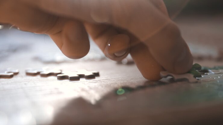 Male hand puzzling, adding pieces to a puzzle- slow motion, tracking shot