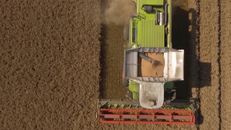 harvest drone flies close over crop dust then claas combine harvester