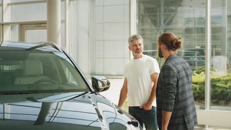 man discussing car purchase in showroom