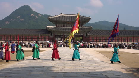 groups of tourists at gyeongbokgung palace square watching spectacular changing of the royal guards ceremony on summer day in seoul