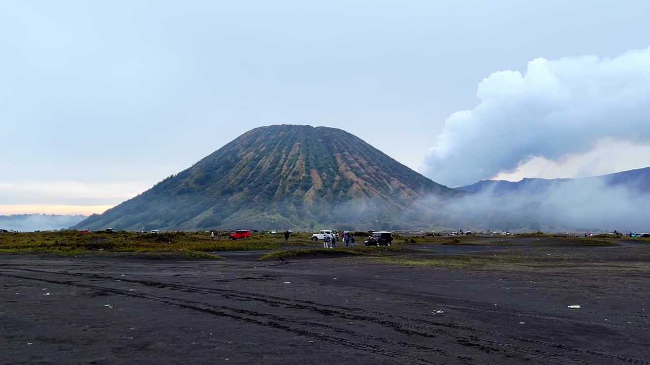 удивительный вид на национальный парк бромо-тенгер-семеру с горами, из которых исходит дым.