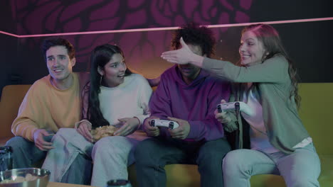 группа друзей играет в видеоигры вместе в одной комнате