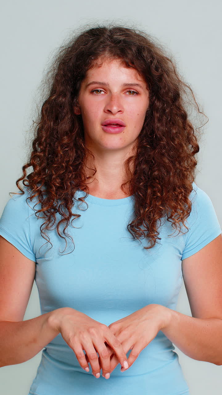 Woman holding hand near ear gesture listening carefully indicating cannot hear confused reaction