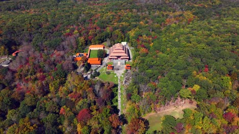 An-aerial-view-of-the-Chuang-Yen-Monastery-on-a-sunny-day,-the-leaves-of-the-trees-begin-to-change-for-autumn
