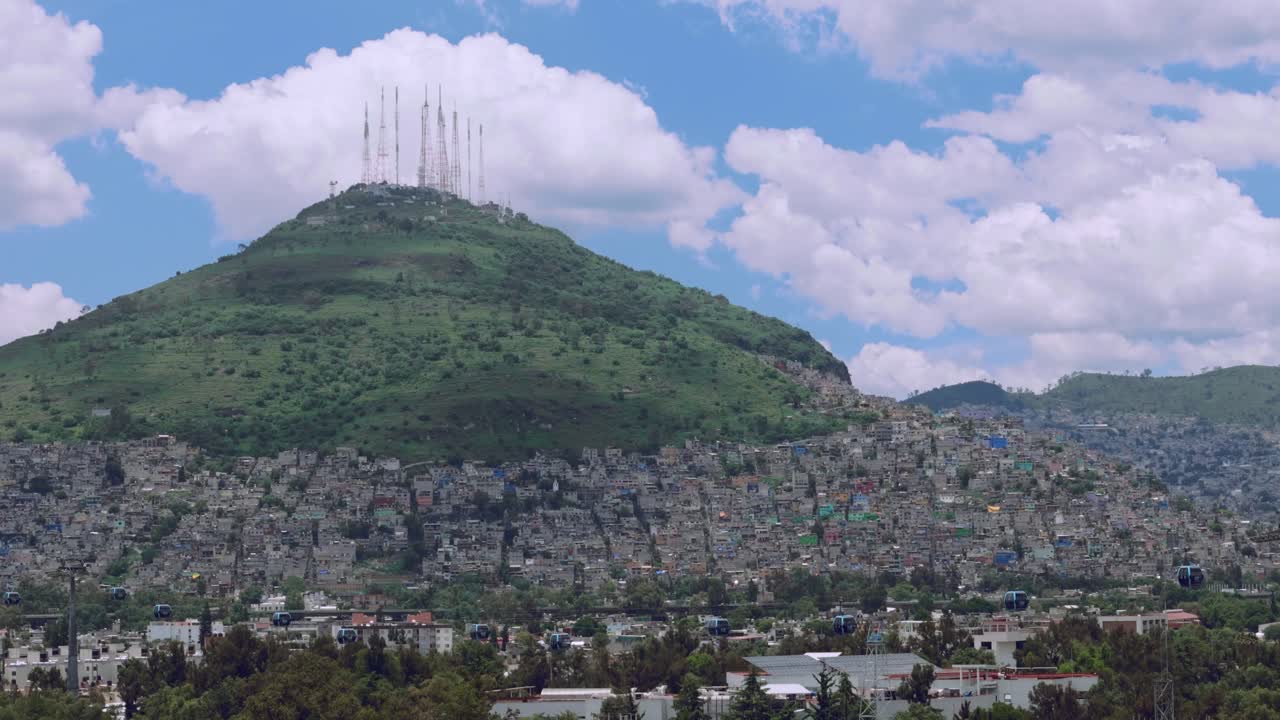 Tilt up to telecom towers on hilltop with houses and greenery in foreground