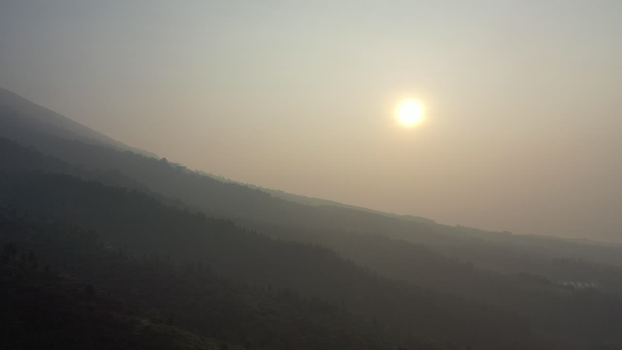 산 위의 안개가 가득한 해가 뜨는 것