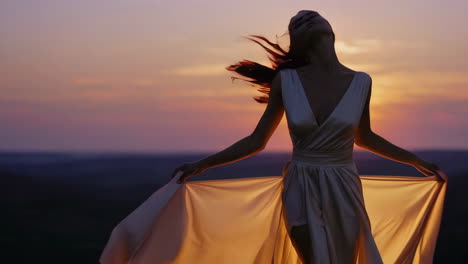 woman in an elegant dress at sunset