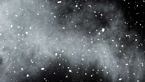 animation of white confetti and white powder, floating on black