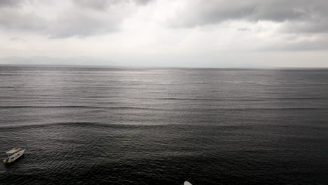 Rain-clouds-above-sea-and-boats-moored-in-shallows-during-moody-scene