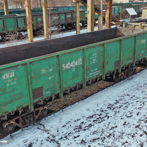 empty containers are moving slowly on rails on the background of the cargo railway station under bridge at countryside. aerial view.