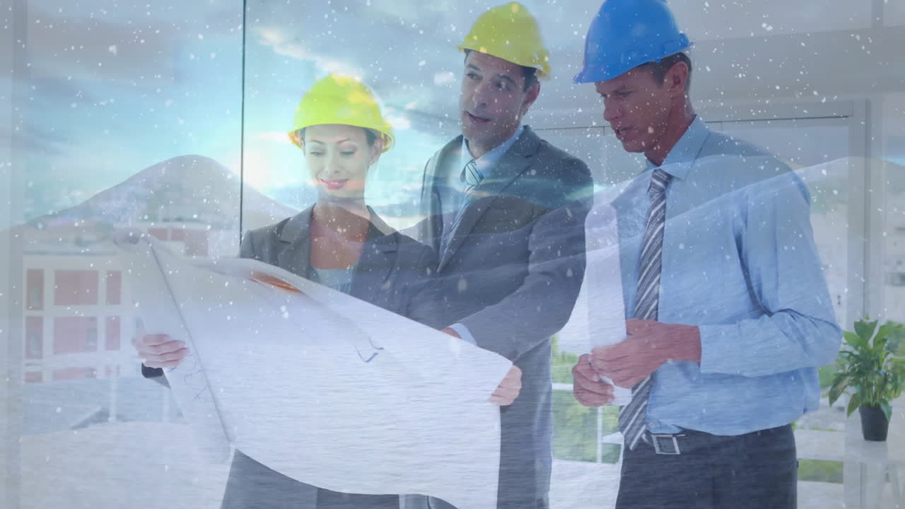In construction site, architects in hard hats reviewing blueprints during snowfall