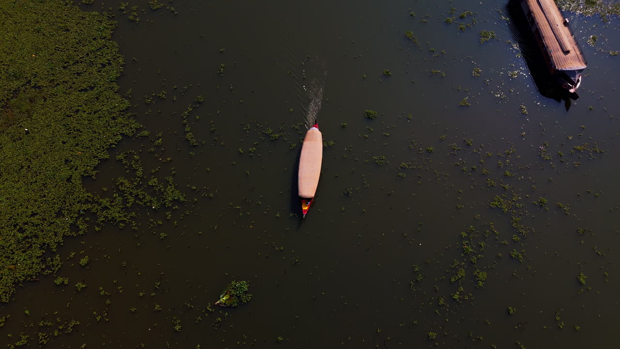 Luftfoto, der vipper mod en husbåd i bagvandene ved Kochi, Kerala, Indien.