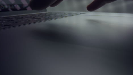mano masculina usando el panel táctil de la computadora portátil. dedos del hombre desplazando el panel táctil en la computadora portátil gris