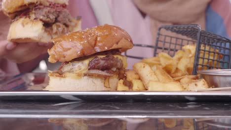 person eating a delicious burger and fries