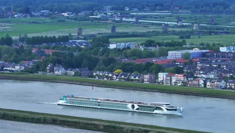 Aerial-View-Of-River-Cruise-Boat-Passing-Through-Kinderdijk