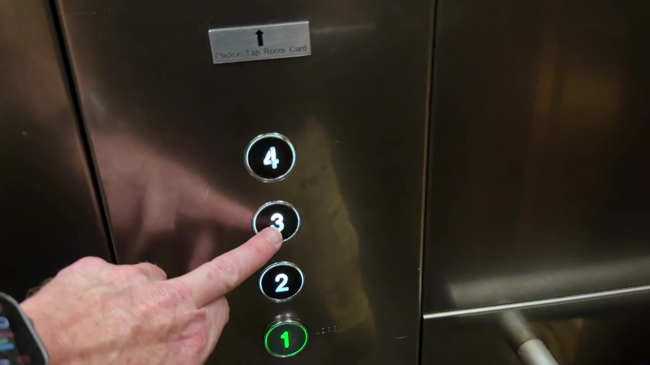 Persona che preme i pulsanti dell'ascensore e le porte si chiudono