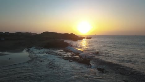 beautiful drone aerial of surfer jumping exciting into the water from the rocks in the ocean of peru