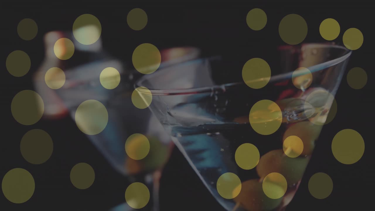 Animation of glowing yellow lights over cocktail glasses