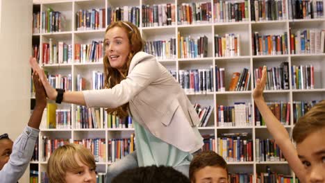 teacher giving high five to kids in library