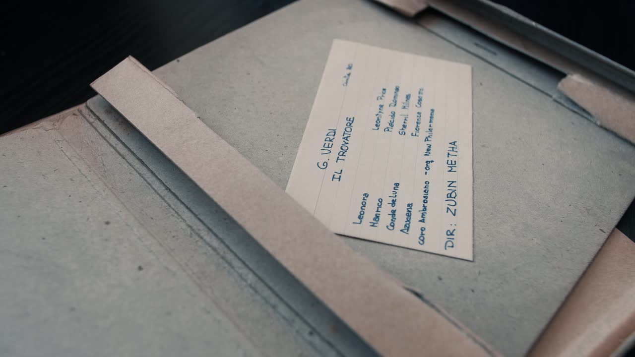 Hands Opening a Box to Reveal Vintage Reel-to-Reel Audio Tape