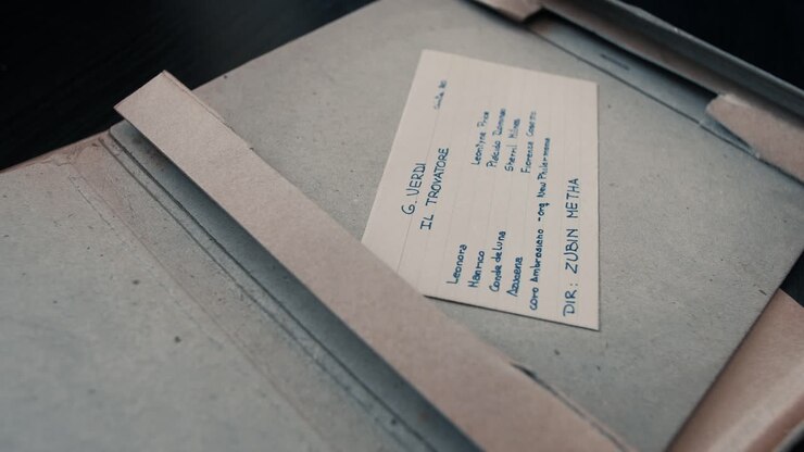 Hands Opening a Box to Reveal Vintage Reel-to-Reel Audio Tape