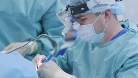 operation to remove tonsils. in modern clinic under deep anesthesia, using latest devices patient removes glands, cold plasma method, cuts swelling in throat, doctor works with new probe, close-up, new medical technologies