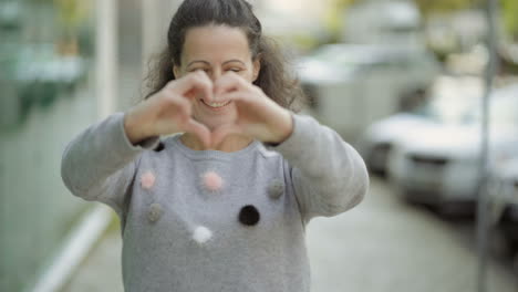 smiling mature woman making heart shape with hands