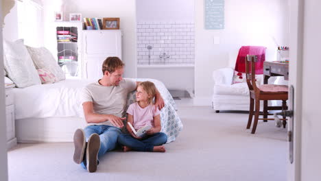 Father-and-daughter-reading-a-book-together-in-her-bedroom