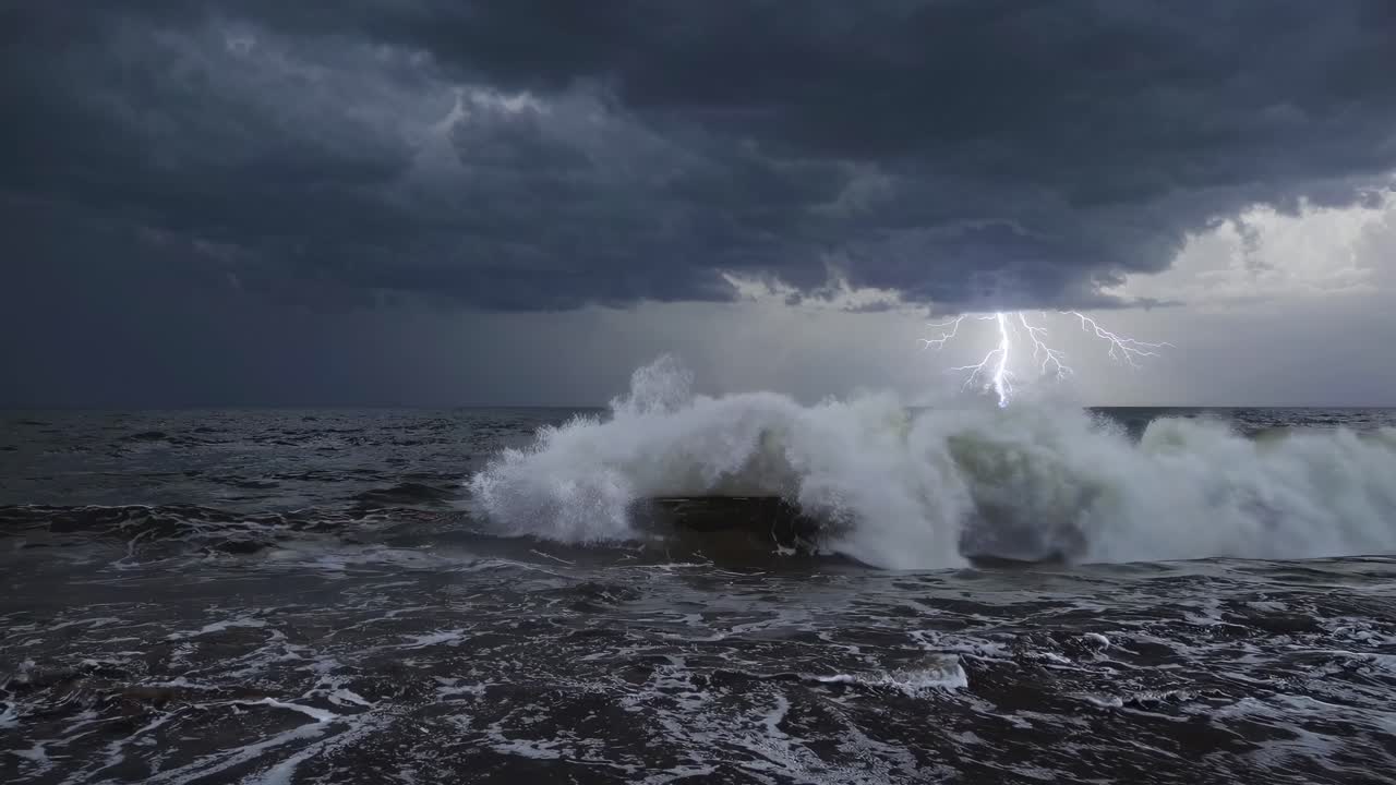 Dramatic seascape video with a low-angle view capturing stormy waves and lightning under dark
