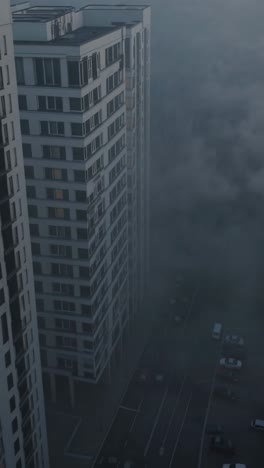 dense fog enveloping a cluster of urban skyscrapers creates a mysterious and evocative atmosphere, capturing the serene beauty of early morning light and the tranquil cityscape