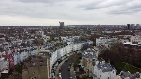 ascending aerial wide shot over notting hill district with colorful buildings in housing area during cloudy day