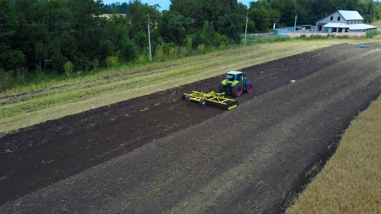 Tractor Plows The Field. Tractor with cultivator handles field before planting