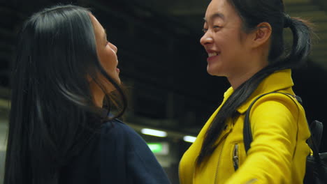 Two-Young-Female-Friends-Hugging-As-They-Say-Goodbye-On-Underground-Train-Station-Platform-1