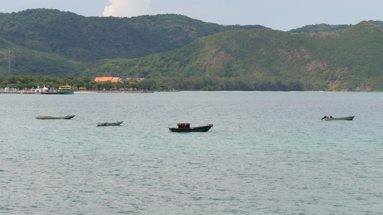 Peaceful Seascape with Fishing Boats and Lush Green Hills