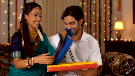 indian husband giving a present to his wife on the occasion of diwali - south indian couple lifestyle