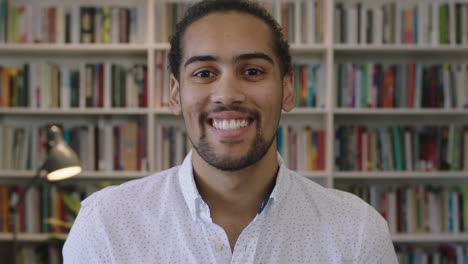 close up portrait of attractive young hispanic man student smiling cheerful in library study background enjoying learning education