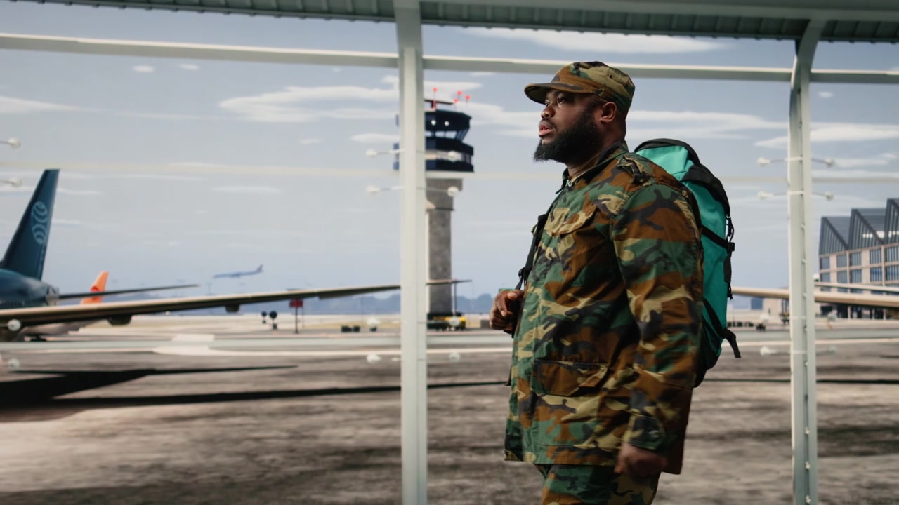 Man returning from military duty walks through airport terminal with backpack