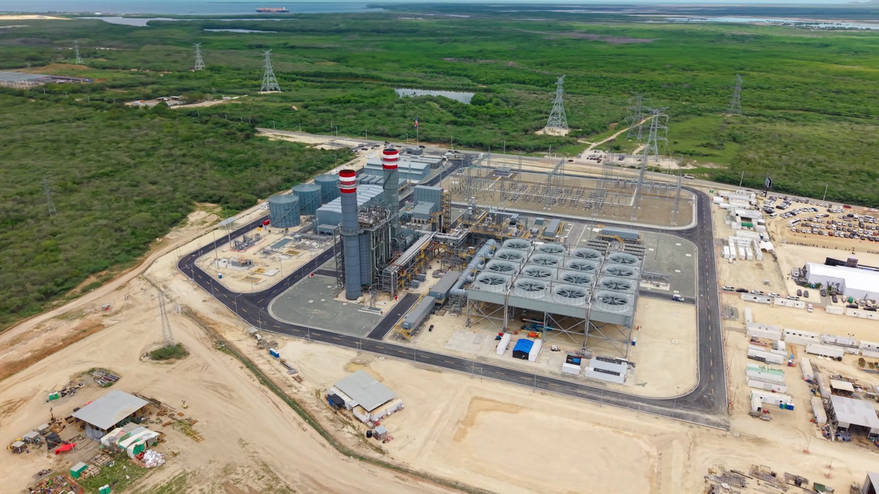 Manzanillo Power Land facility surrounded by green landscape and power lines in Montecristi, Dominican Republic. Aerial drone orbiting