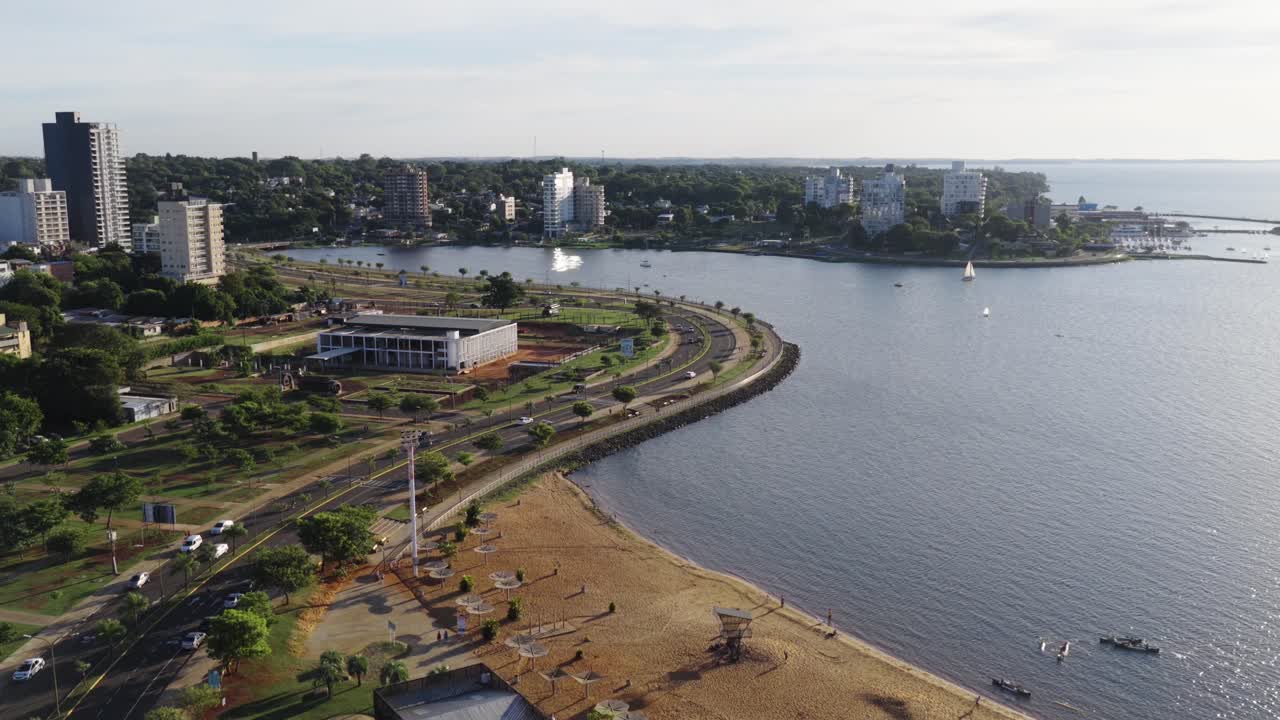 Aerial view of coastal promenade in Posadas with buildings and calm El Brete bay waters, Misiones, Argentina.