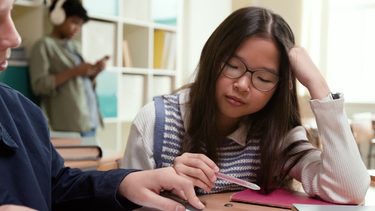 Tired Student Studying with Classmates in a School Library or Classroom