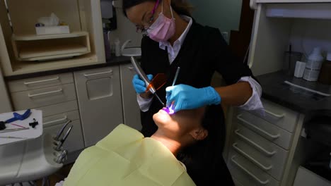 female dentist examining a patient with tools 4k