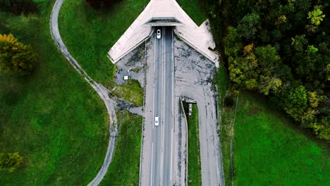 vista aérea sobre el túnel de la autopista de entrada en francia. sólo campos de hierba y árboles alrededor de las carreteras. coches y camiones conduciendo en las carreteras