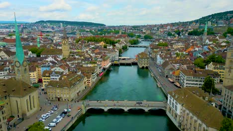 4k drone video of boats on the limmat river between the münsterbrücke and rathausbrücke bridges in downtown zurich, switzerland